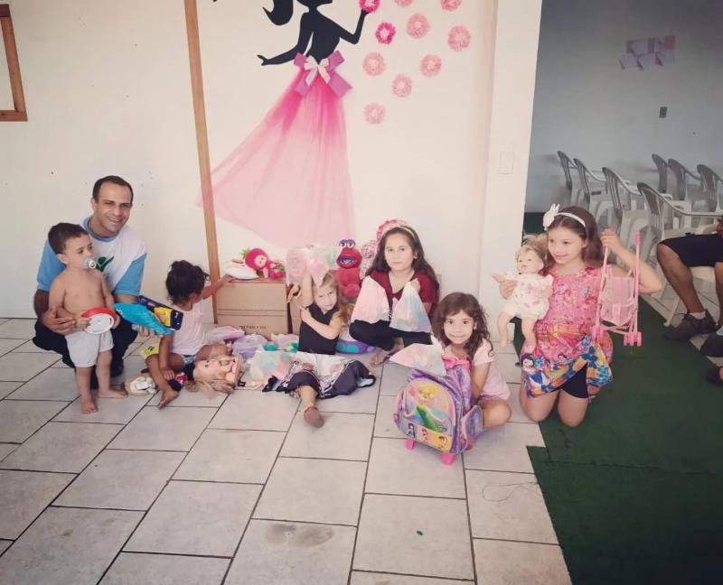 Crianças recebem doacões de brinquedos e biscoitos